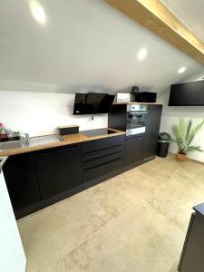 a kitchen with black cabinets and a counter top at Cozy Alpenloft Chiemsee by Dollop Living in Bernau am Chiemsee +18 photos