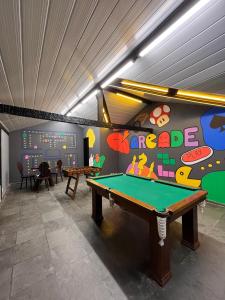 a room with a pool table and a wall with the words garage at Pousada Sonho Verde in Rio das Ostras