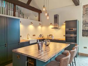 a kitchen with a large wooden island with bar stools at 3 Bed in Dulverton oc-t32975 in Dulverton