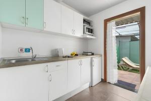 eine Küche mit weißen Schränken und einer Spüle in der Unterkunft Country Studio Near Fataga in Artedara