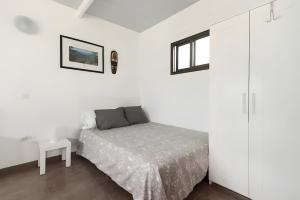 ein weißes Schlafzimmer mit einem Bett und einem Tisch in der Unterkunft Country Studio Near Fataga in Artedara + 35 Fotos