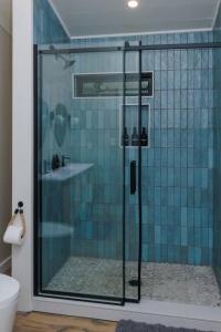 a bathroom with a shower with blue tiles at 8 Min to Zip Lines Unique Stay King Bed in Rogers +68 photos