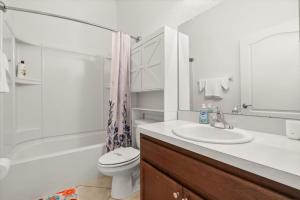 a bathroom with a sink and a toilet and a shower at Family-Friendly 3BR Getaway Hot Tub Game Room Fun in Lake of the Hills +34 photos