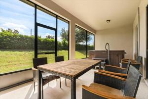 a dining room with a table and chairs and windows at Family-Friendly 3BR Getaway Hot Tub Game Room Fun in Lake of the Hills