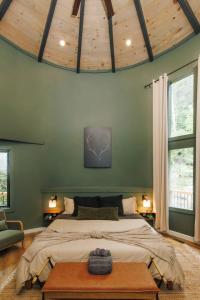 a bedroom with a large bed and a wooden ceiling at NEW Unique Stay w King Beds and Private Hot Tub in Rogers