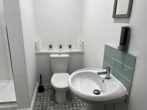 a white bathroom with a toilet and a sink at Beach & city Homestay in Waterloo