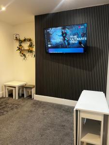 una sala de espera con 2 mesas y TV en la pared en Crosby Marina Apartment, en Waterloo