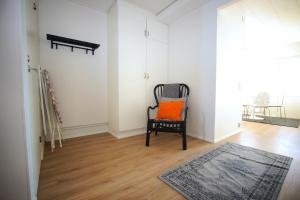 an orange pillow sitting on a chair in a room at Convenient Apartment for 4 in Karvsor