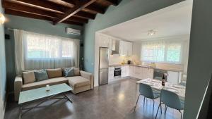eine Küche und ein Wohnzimmer mit einer Couch und einem Tisch in der Unterkunft Spacious Country House Near Fataga in Artedara