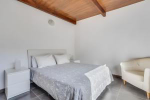 a white bedroom with a bed and a chair at Country House Near Fataga in Artedara +32 photos