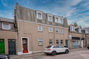 a white car parked in front of a building at Luxury 3 bedroom apartment in Stonehaven