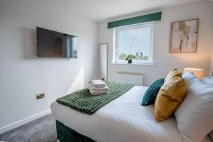 a bedroom with a bed with a television on the wall at Luxury 3 bedroom apartment in Stonehaven