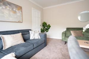 a living room with a couch and a table at 3 BDR House At Caledonia Luxe Stays Short Lets & Serviced Accommodation Falkirk in Polmont +23 photos