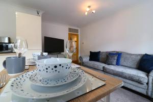 a living room with a table with bowls and wine glasses at Cosy 1 bed flat in central Ayr in Ayr
