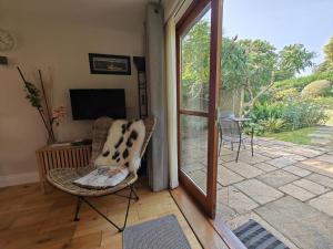 a living room with a chair and a sliding glass door at 1 Bed in Fowey oc-p33360 in Fowey
