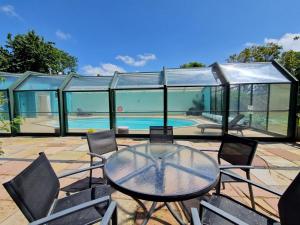 a glass house with a table and chairs next to a swimming pool at 1 Bed in Fowey oc-p33360 in Fowey