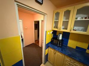 a kitchen with yellow and blue walls and cabinets at Zolhome in Warsaw