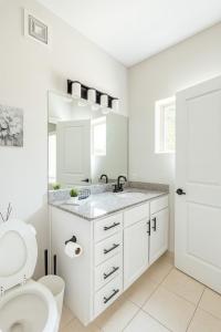 a white bathroom with a toilet and a sink at Stylish Condo 3 Bedroom with Pool Table in Homewood +21 photos