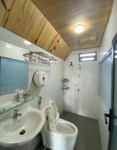 a white bathroom with a sink and a toilet at Mộc Hoa Viên Homestay in Ấp Thiện Lập