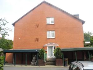 une grande maison en briques rouges avec une porte blanche dans l'établissement Spacious 3 bedroom house in Norderstedt-Hamburg, à Norderstedt