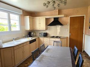 a kitchen with a table and a sink and a counter top at Gîte Les Treilles in Balnot-sur-Laignes
