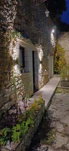 a stone building with a door and a sidewalk at Troglo la Roche Tourangelle et vélos in Civray-de-Touraine +1 photo