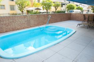 uma grande piscina azul num pátio em Coqueiros Express Hotel em Maceió