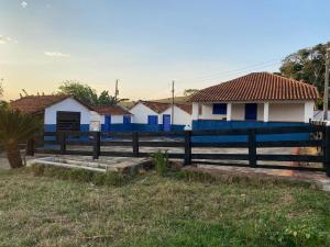 a blue fence in front of some houses at Fazenda Brasileiro in Passos +3 photos