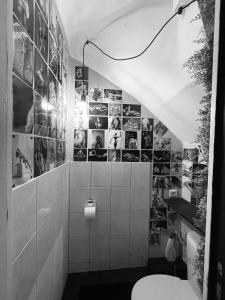a bathroom with a toilet and pictures on the wall at Triplex sensuel in Chauny +5 photos