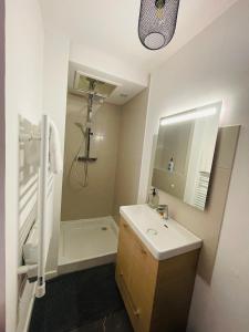 a bathroom with a sink and a toilet and a shower at Triplex sensuel in Chauny