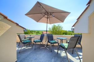 a patio with a table and chairs and an umbrella at Apartment Lipovac in Malinska