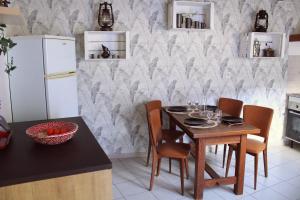 a kitchen with a table and chairs and a refrigerator at Maison plein centre in Brain-sur-Allonnes