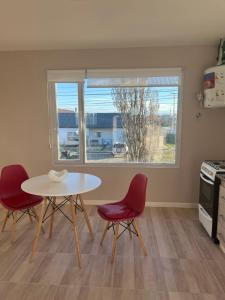 a kitchen with a table and two chairs and a window at Puesta del Sol Apart in Río Gallegos +21 photos