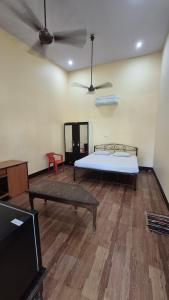 a room with a bed and a table and a couch at Furtado's Beach Resort in Benaulim +16 photos