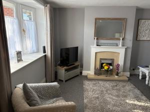 a living room with a fireplace and a television at Flat 1. Cleethorpes apts in Cleethorpes