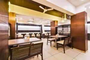 a dining room with tables and chairs in a restaurant at Hotel Shirdi Park Inn 80 Meters From Sai Samadhi Temple in Shirdi