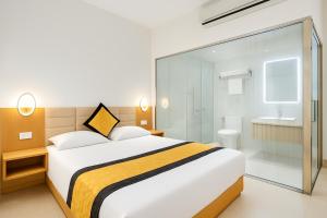 a bedroom with a large bed and a bathroom at S79 Son Mi Hotel Saigon in Ho Chi Minh City