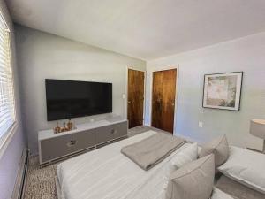 a bedroom with a bed with a flat screen tv at NEW-Queen Bed-Yard Space-Quiet Neighborhood-NH- in Hudson