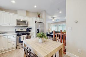 une cuisine avec des armoires blanches et une table en bois dans l'établissement Sierra Solace, à South Lake Tahoe