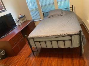 a bedroom with a bed and a dresser with a television at Homestayyy in Dallas