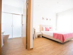 a bedroom with a bed and a bathroom with a tub at Tavira Monte in Tavira