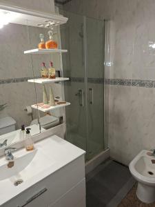 Un baño con ducha, lavabo e inodoro. en Constança House, en Corroios