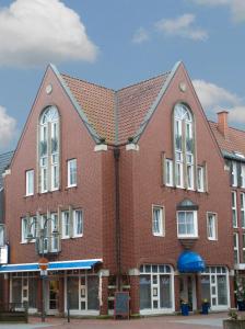 メッペンにあるAltstadt Hotel Meppenの白い窓のある大きな赤レンガ造りの建物