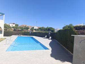 a swimming pool in the middle of a yard at azahar playa apartmento in Mazarrón