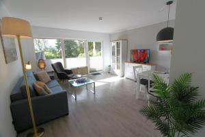 a living room with a couch and a table at Denghoog- Osetal 10, App 2 in Wenningstedt