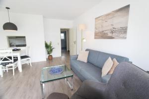 a living room with a couch and a table at Denghoog- Osetal 10, App 2 in Wenningstedt