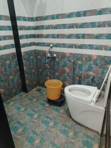 - une salle de bains avec un seau à côté des toilettes dans l'établissement Hotel Nitharwal Palace, à Khātu