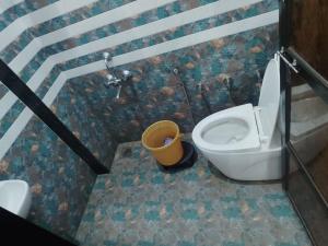 La salle de bains est pourvue de toilettes et d'un seau. dans l'établissement Hotel Nitharwal Palace, à Khātu