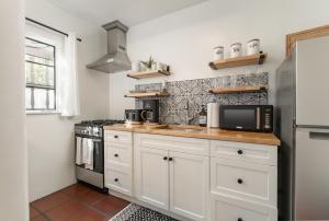 kuchnia z białymi szafkami i mikrofalówką w obiekcie 1 Bedroom Casita - Casa Blanca w mieście Montecito