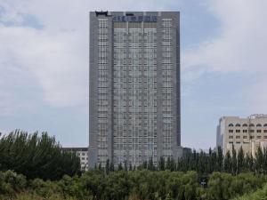 a tall building with trees in front of it at Mercure Hohhot Downtown in Hohhot